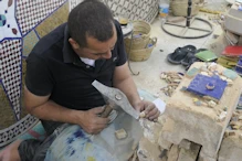 Chiping tiles into shape for mosaic