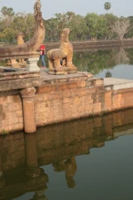 Guardian lion on moat bridge + reflection