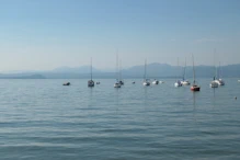 Sailing boats with the mountains in different blues behind