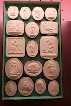 Some of a large collection of plaster cameos of works of art